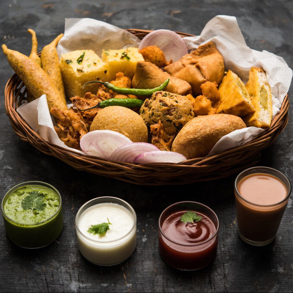 Indian evening snacks in a basket with chutney and ketchup